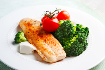 Fried Basa Fillet with sauce, broccoli and fresh tomato.