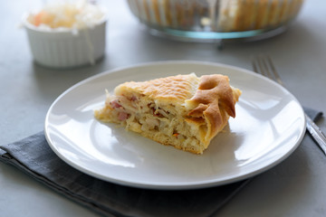 Slice of homemade sauerkraut pie on gray wooden table. Cabbage cake tradition russian food