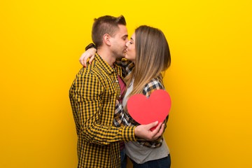 Couple in valentine day holding a heart symbol and kissing