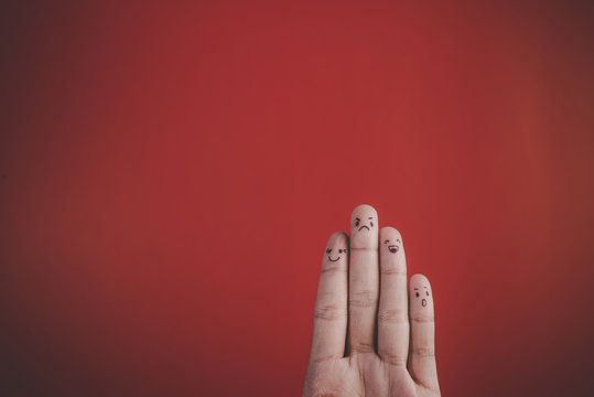 Finger with emotion on red background