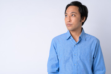 Portrait of Japanese businessman thinking against white background