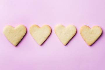 Obraz premium Homemade cookies in the shape of a heart on a pastel pink background. Copy space. Concept Valentine's Day