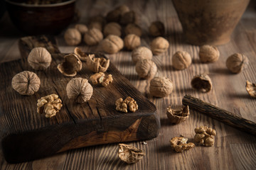Close up view composition of walnut kernels and whole walnuts on rustic cuting desk. Selective focus 2