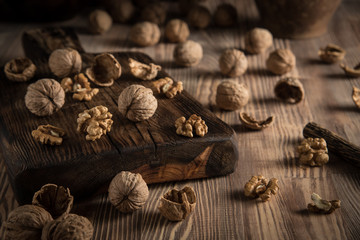 Close up view composition of walnut kernels and whole walnuts on rustic cuting desk. Selective focus 3
