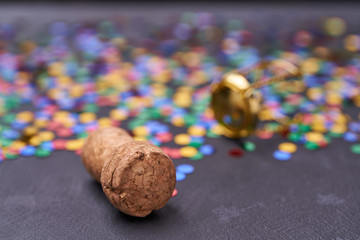 Corks from champagne with confetti on a black background with  selective focus