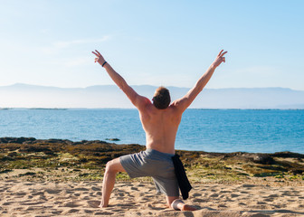Fototapeta na wymiar young muscular guy posing on a ocean background