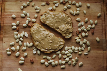 Fototapeta na wymiar Delicious peanut butter sandwich breakfast and peanut on wooden table background. Sweet food, breakfast concept