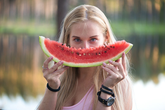Young girl holding red slice of watermelon