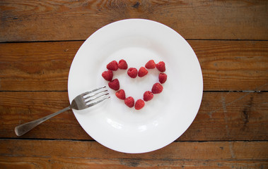 Raspberries fruit Heart on a white background. Fresh organic and ripe love symbol