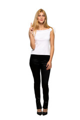Young blonde woman pointing with the index finger a great idea over isolated white background