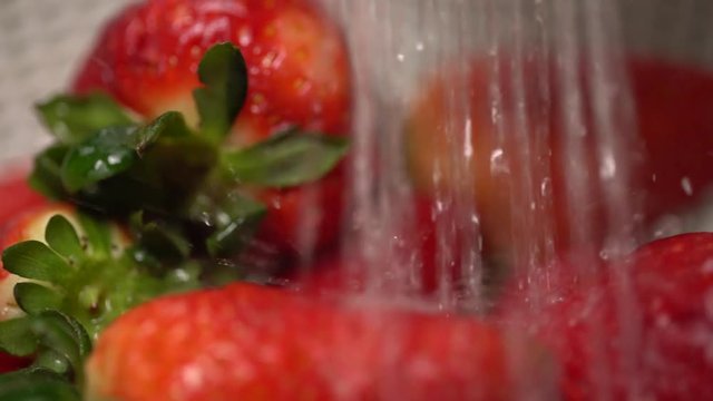 Washing strawberries extreme close up in a strainer. Shot on Batis 25mm on a Sony A7iii and slowed to 25%.