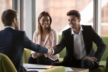Happy arabic businessman handshaking caucasian man in suit at multi-ethnic meeting, diverse partners shaking hands after signing contract making business deal, international collaboration concept
