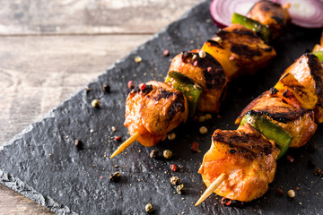 Chicken shish kebab with vegetables on wooden table. Copyspace