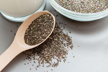 Chia seeds in wooden spoon on grey background.copy spase.Chia seeds in wooden spoon, lying on dark stone background
