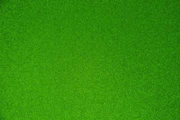 Fototapeta na wymiar An abstract green background made of twinkling glitter that is great for a background for Christmas and other celebrations.