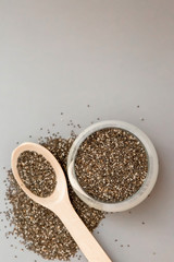 Chia seeds in wooden spoon on grey background.copy spase.Chia seeds in wooden spoon, lying on dark stone background