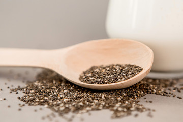 Chia seeds in wooden spoon on grey background.copy spase.Chia seeds in wooden spoon, lying on dark stone background