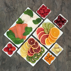 Stress and anxiety relieving fresh food with salmon, chicken, fruit and vegetables in porcelain dishes on marble background. Health foods that help relaxation and reduce chronic fatigue & depression. 