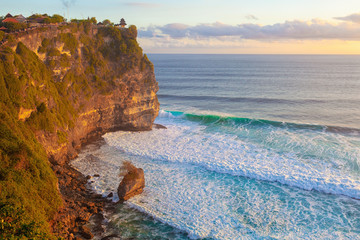 Travel vacation on exotic islands background - Sunset on the ocean coast with rocks beach Bali Indonesia with Waves and cliffs 