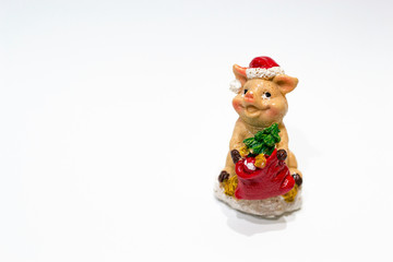 Christmas toy ceramic pig with fir tree and hat as a symbol of Chine new 2019 year isolated on white background. Concept of winter holidays, copy space.