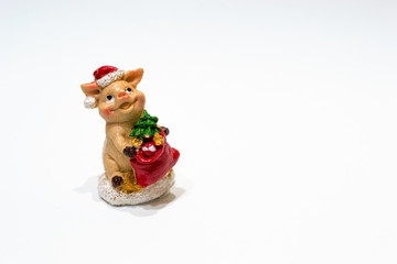 Fototapeta na wymiar Concept of winter holidays, copy space. Christmas toy ceramic figurine pig with fir tree and hat as a symbol of Chine new 2019 year isolated on white background.