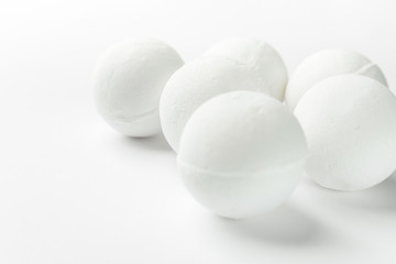 Handmade salt bath bombs in balls shape from organic vegan natural ingredients on white background. Spa wellness body care wellbeing concept. Clean minimalist style. Copy space