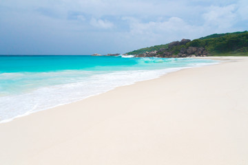 Fototapeta na wymiar The beach on the Seychelles with white sand turquoise water and blue sky
