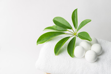 Handmade salt bath bombs in balls shape from organic vegan natural ingredients on white towel green house plants. Spa wellness body care wellbeing. Clean minimalist style