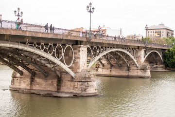 Fototapeta na wymiar Vista del puente de Triana desde la calle Bétis de Sevilla, Andalucía, España