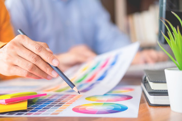 Graphic design partners working together renovation and technology concept - on a desktop computer and selection using some color swatches