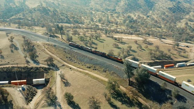 Only a freight train's that are over 4000 feet long are able to cross over their own railroad cars in the lower tunnel of the Tehachapi railroad Loop. Aerial camera shoots the action from 280 feet up.