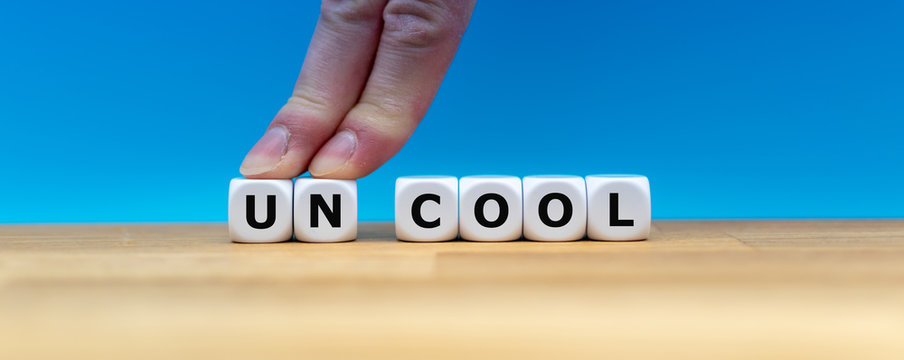Dice form the word "UNCOOL" while two fingers push the letters "UN" away in order to change the word to "COOL".
