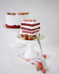 A piece of strawberry cake on white cakestand