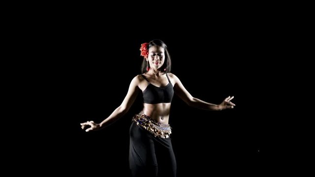 Attractive young woman dancing zumba in the studio. Shot in 4k resolution with dark background