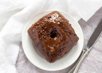 Doughnut with chocolate glaze and chocolate nibs on top. Pastries concept. Fresh and delicious. White background.