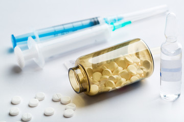 White pills and squirt on white background. Medicine concept.