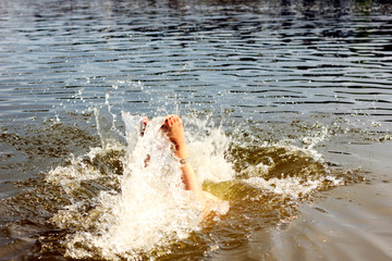 beautiful girl in black bikini bathes in the river on the beach in summer