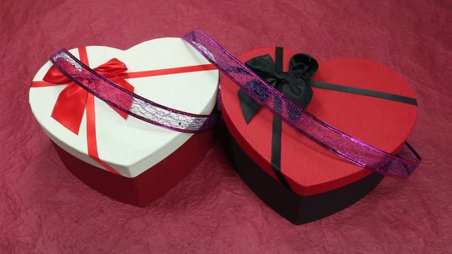 Gift box in the form of a heart with a bow. A gift for the holiday on the day of all lovers. Romantic decor on March 8th. Roses and tinsel. A glass of champagne.