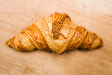 Tasty buttery croissants on old wooden table