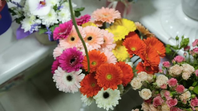Man choose a flower type for flowers bouquet for his wife at flower shop