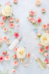 Natural Skincare Ingredients. Spa setting with flowers,  rose moisturizing cream and essential oil. Spa theme. Top view, blank space, textured background