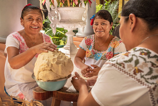 Women making Tortillas. Group of smiling cooks preparing flat bread tortillas in Yucatan, Mexico