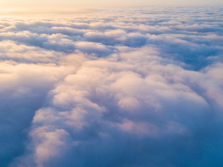 Obraz na płótnie Canvas Aerial view White clouds in blue sky. Top view. View from drone. Aerial bird's eye view. Aerial top view cloudscape. Texture of clouds. View from above. Sunrise or sunset over clouds