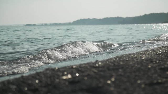 Calm waves crashing on a beach during sunset.