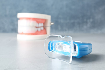 Teeth whitener on table against blurred background. Space for text