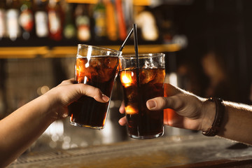 Young couple with glasses of cola in bar, closeup - obrazy, fototapety, plakaty