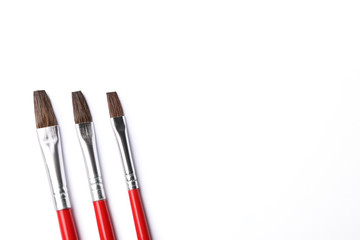 Fototapeta premium Different paint brushes on white background, top view. Space for text