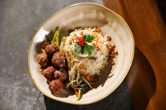 Plate with rice and meat balls served on table