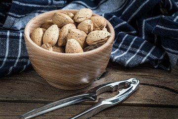Almonds in-shell in wooden bowl.