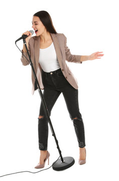 Young stylish woman singing in microphone on white background